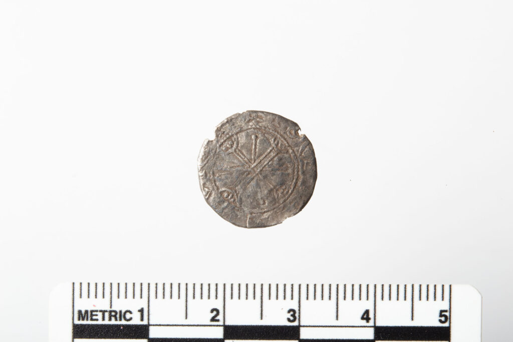 The reverse side of the object clearly shows the copper plate that was added, with the edge of the coin folded around it. Credit: Hege Hollund, Archaeological Museum, University of Stavanger
