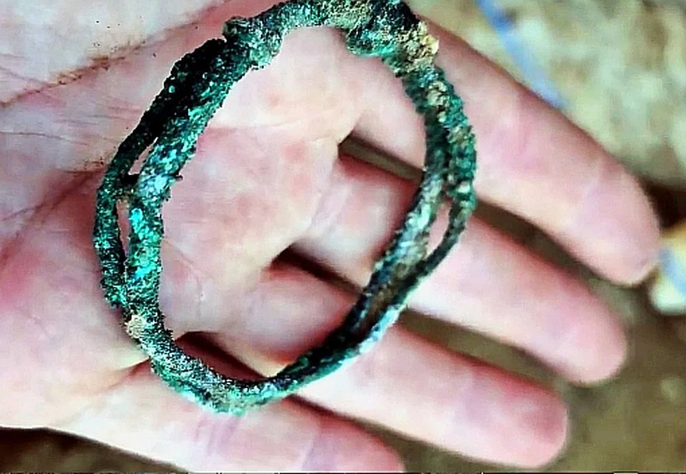 A bronze bracelet and a beaded necklace were found beside the remains — modest grave goods suggesting a ceremonial burial. Credit: Artesian Archaeological Expedition (AAE) via VK