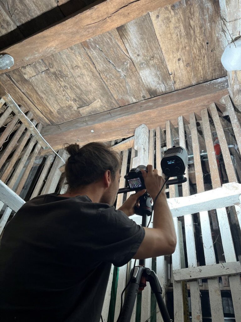 Archaeologists closely examine the cellar ceiling structure containing the reused medieval ship timbers. Credit: Landesamt für Denkmalpflege