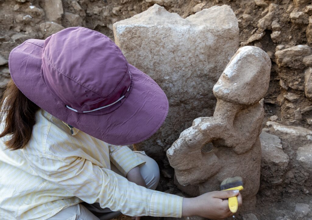 Archaeologists carefully clean the newly discovered 11,000-year-old human-and-leopard statue during excavations at Karahantepe. Credit: Ministry of Culture and Tourism / Mehmet Nuri Ersoy