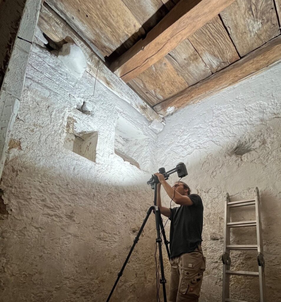 Archaeologists closely examine the cellar ceiling structure containing the reused medieval ship timbers. Credit: Landesamt für Denkmalpflege