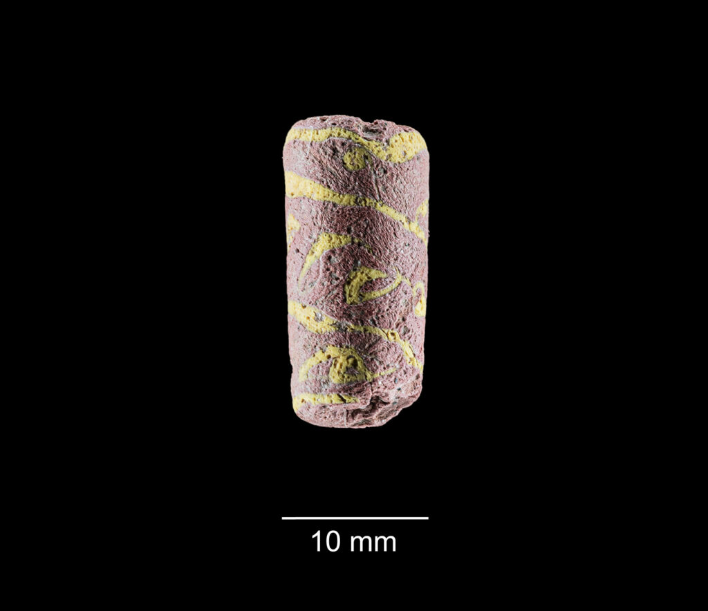 An early medieval red-and-yellow glass bead discovered near later drainage features at the Singen site.