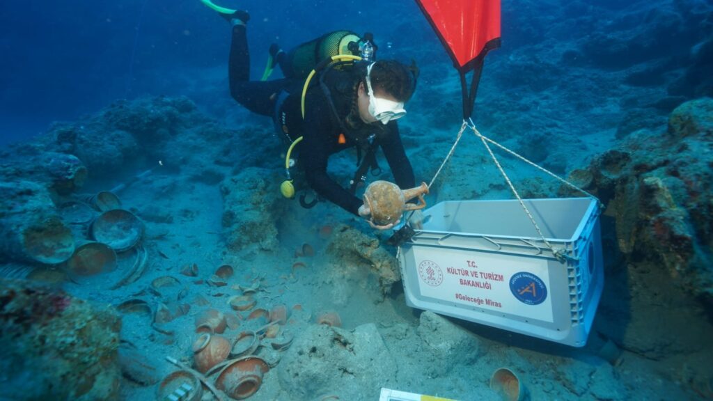 Underwater archaeologist recovering an ancient ceramic vessel from the Adrasan shipwreck.
