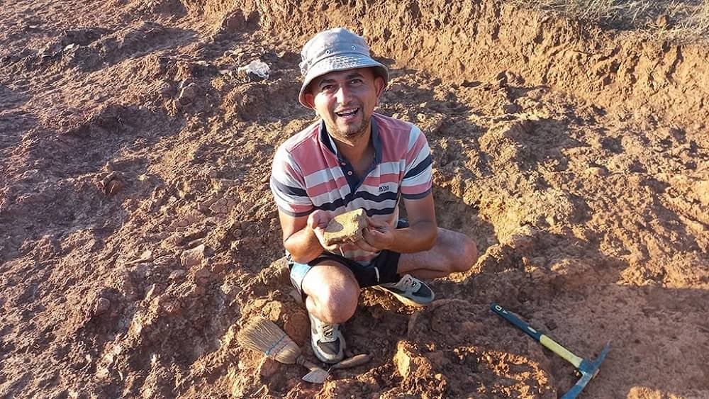 
Archaeologist holding a Neolithic ceramic artifact at the Atici-Spomenik excavation site near Lake Dojran.