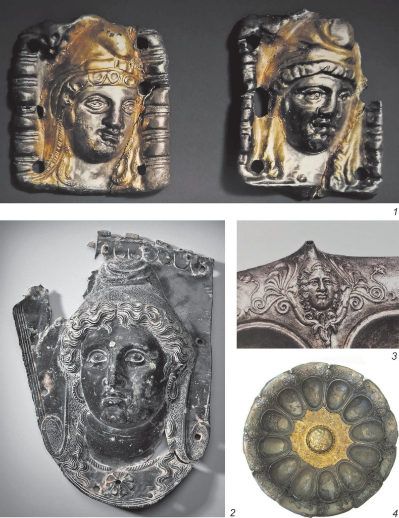 Ancient metal objects showing female heads identified as Amazons, including gilded plaques, a cuirass shoulder piece, and a silver bowl.