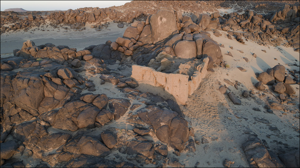 Church of Miseeda in Sudan with the ancient petroglyph visible on the rock behind the building.