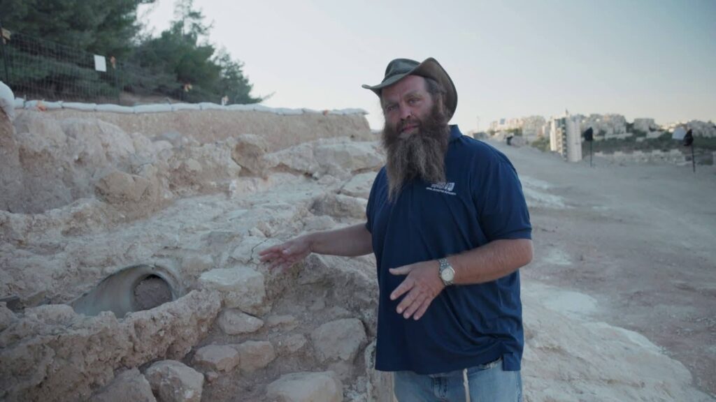 An archaeologist stands beside an Ottoman-era ceramic water pipe within Jerusalem’s 2,000-year-old Lower Aqueduct.