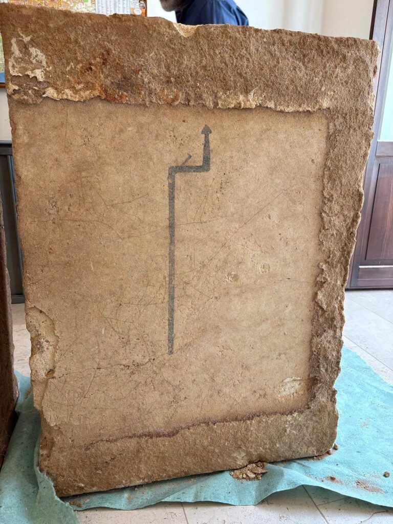 Key-shaped painted symbol preserved on an ancient stone slab from Manduria's Tomb 17.