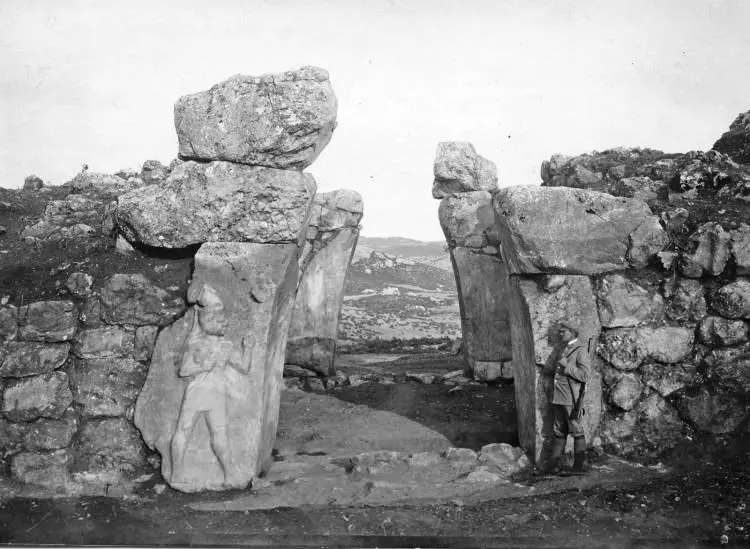 
Archival photograph of the King's Gate at Hattusa, featuring massive stone blocks and a carved warrior figure on the left side of the entrance.