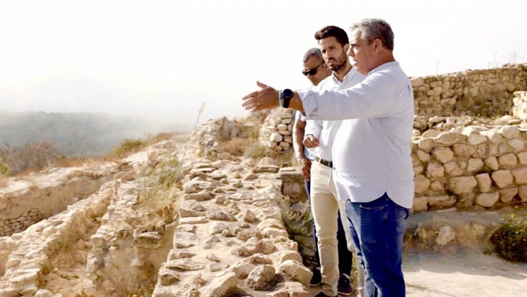 Patricio Sánchez and Antonio Huéscar standing among the excavated stone structures at La Almoloya in Spain.