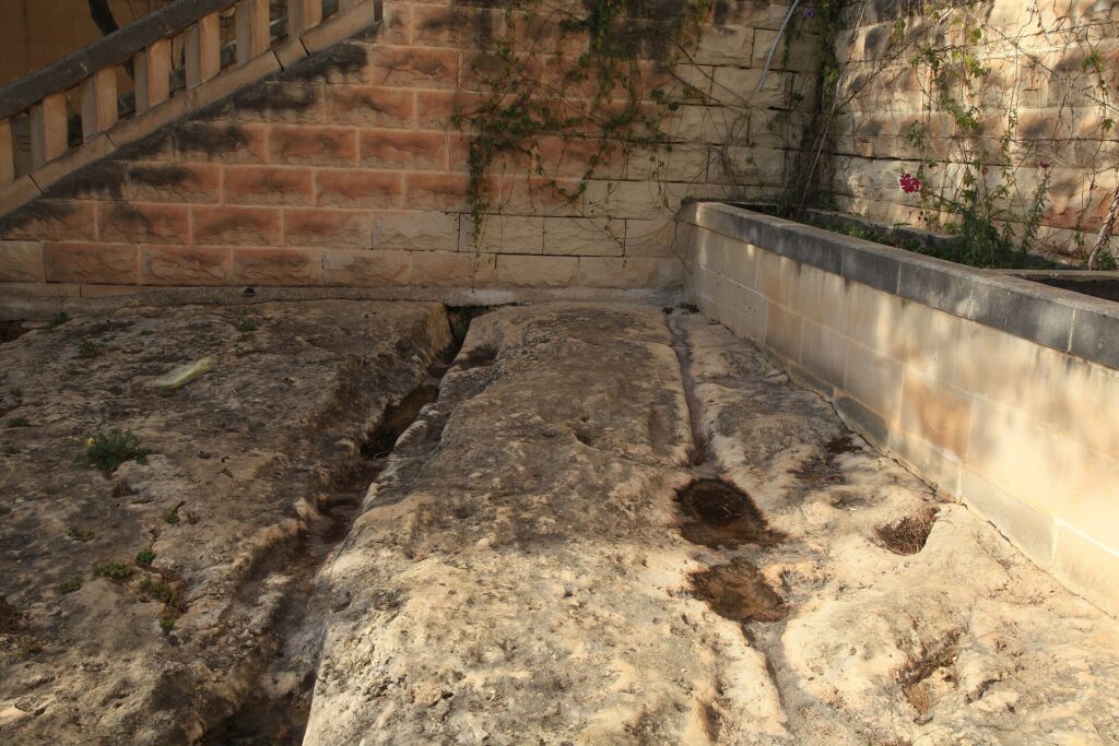 Ancient parallel cart ruts crossing the limestone landscape near Għar Dalam in Birżebbuġa, Malta.