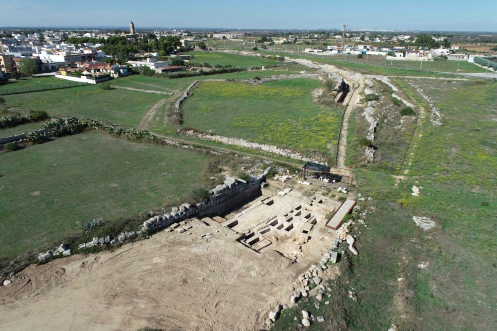 Aerial photograph of the Messapian archaeological park at Manduria, showing excavated tombs and ancient walls.