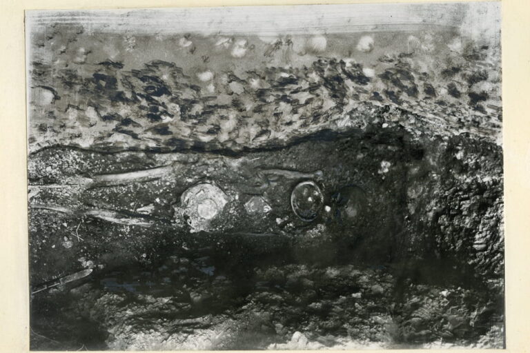 Presumed male skeleton in Pit I of the Dendra tholos tomb, with grave goods visible in their original positions around the body.
