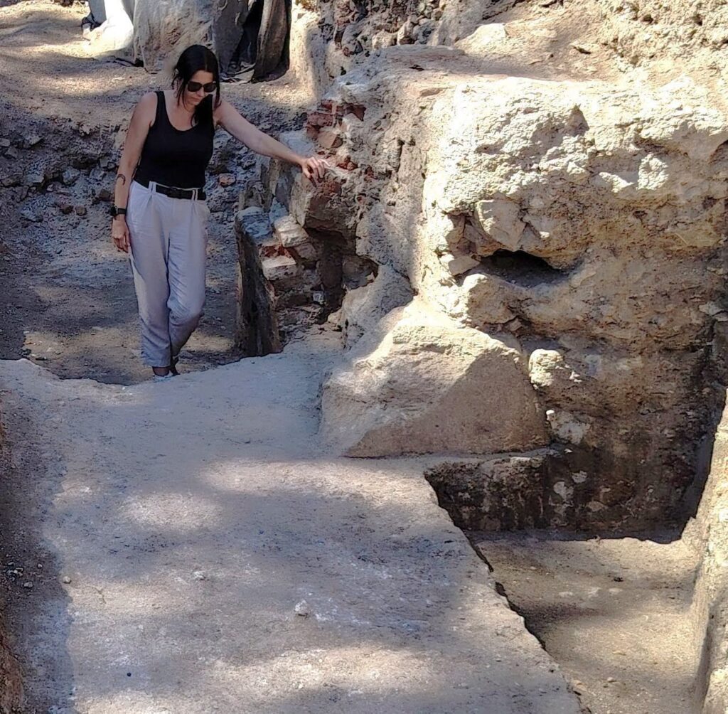 Archaeologist examining the excavated foundations of the Porta Praetoria at Apulum in Alba Iulia.
