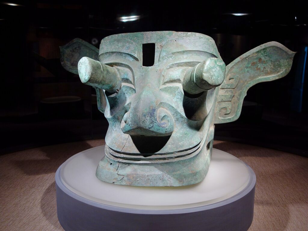 
Ancient Sanxingdui bronze mask with exaggerated eyes and elaborate facial features.