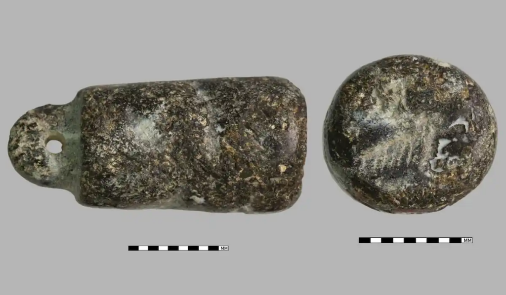 Two views of an ancient cylinder seal recovered from a woman's Iron Age burial at Metsamor, Armenia, showing its worn surface and perforated end.