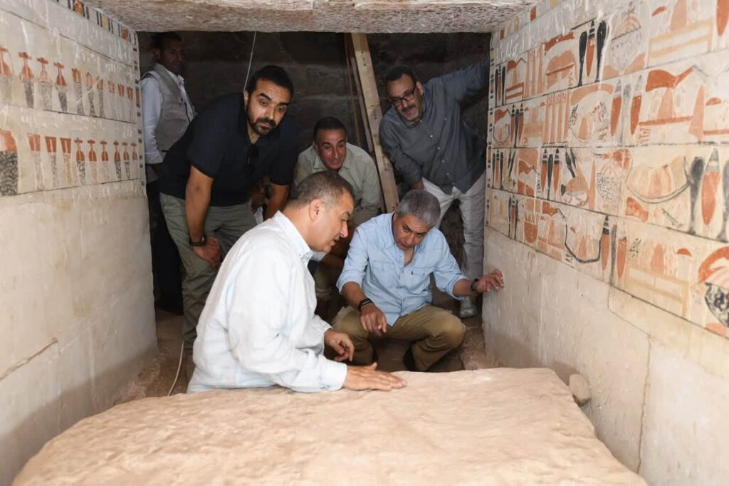 Egyptian officials and archaeologists examining the decorated interior of Weni's newly discovered tomb at Saqqara.