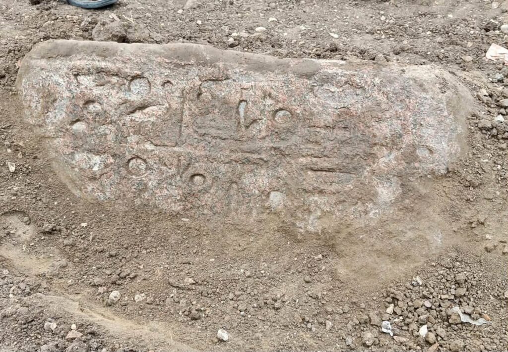 Ancient Egyptian hieroglyphic inscriptions carved into a weathered pink granite block discovered in the Nile Delta.