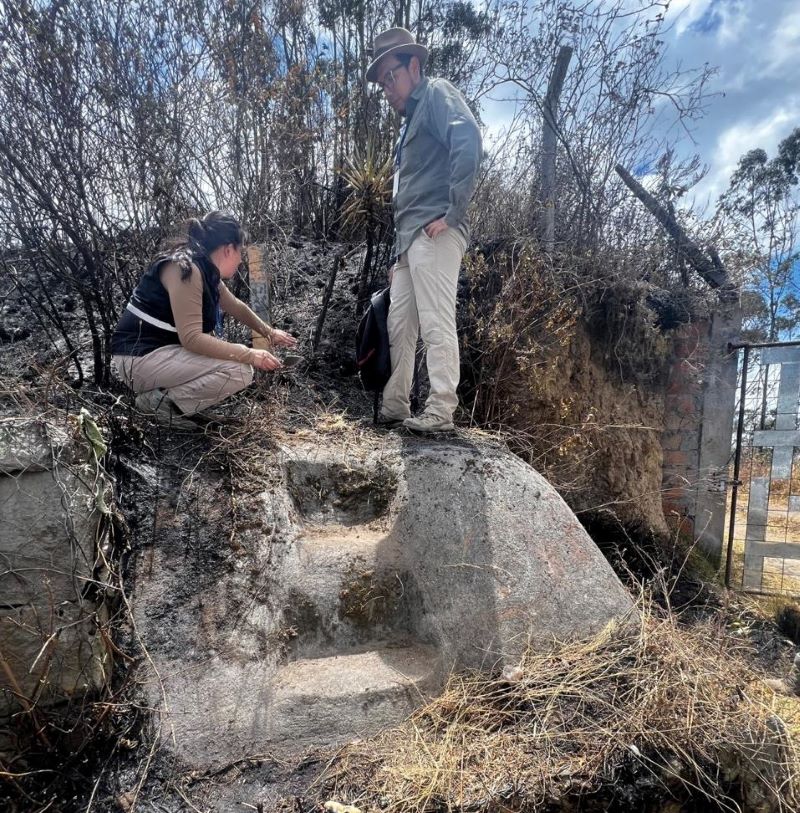 Archaeologists examining a rock-cut stairway exposed after a wildfire on Cerro Casitagua near Quito, Ecuador.